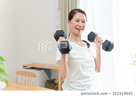 Healthy senior woman doing muscle training with dumbbells 101919685