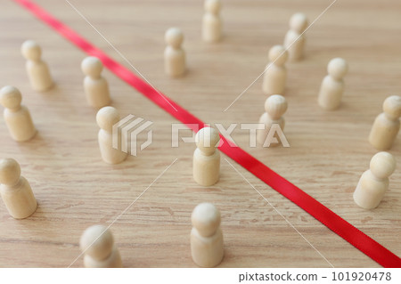 Red strip divides wooden figurines of opponents on table 101920478