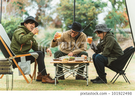 Asian camper toasting with beer at campsite with male friends Asian camper toasting with beer at campsite with male friends 101922498