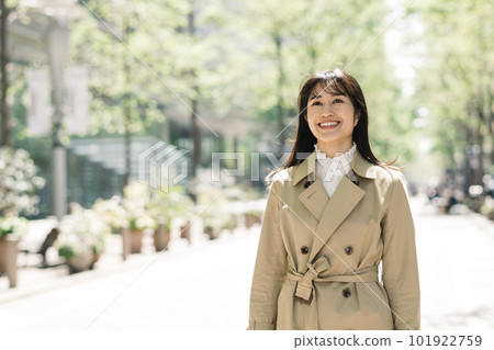 穿風衣的年輕女人在城市裡行走 穿風衣的年輕女人在城市裡行走 101922759