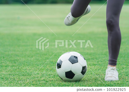 The feet of a woman who kicks and shoots a soccer ball The feet of a woman who kicks and shoots a soccer ball 101922925