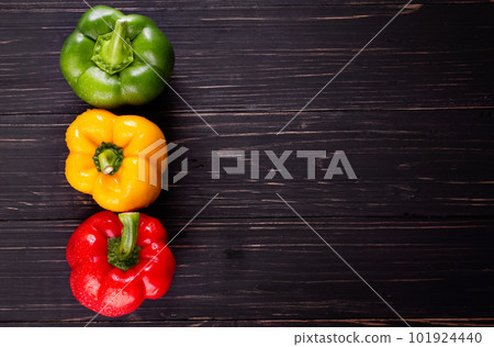 Three sweet peppers on a wooden background, Cooking vegetable salad Three sweet peppers on a wooden background, Cooking vegetable salad 101924440