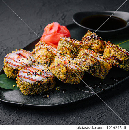 Served warm sushi with ginger and wasabi on a black stone plate 101924846