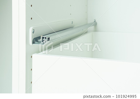 Drawer rail inserted into cabinet, fixed with self-tapping screws. Assembling white dresser or wardrobe Drawer rail inserted into cabinet, fixed with self-tapping screws. Assembling white dresser or wardrobe 101924995