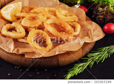 Oven baked breaded calamari rings served with lemon Oven baked breaded calamari rings served with lemon 101925199