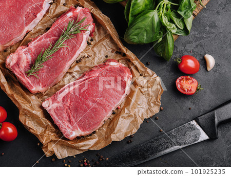 Raw strip loin steaks on baking paper Raw strip loin steaks on baking paper 101925235