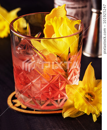 Glass of negroni cocktail decorated with flowers 101925247