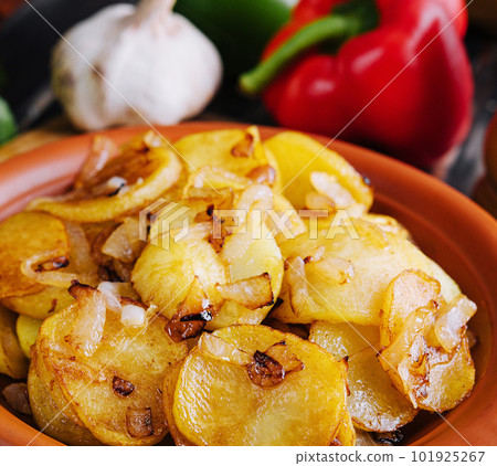 Fried potatoes with onions on wooden tray 101925267