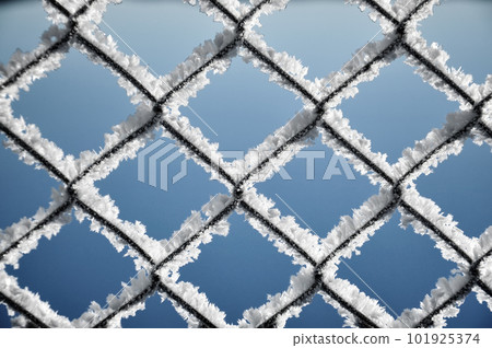 Metallic net covered with hoarfrost. Extreme cold weather concept Metallic net covered with hoarfrost. Extreme cold weather concept 101925374