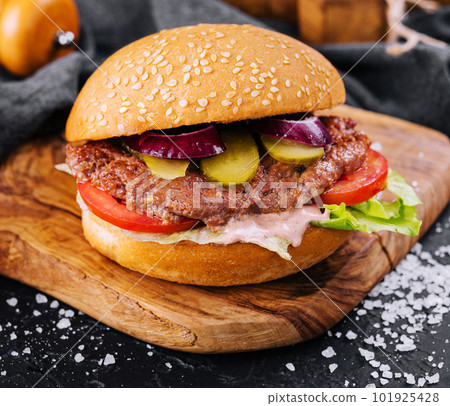Close-up of home made burger on wooden tray Close-up of home made burger on wooden tray 101925428