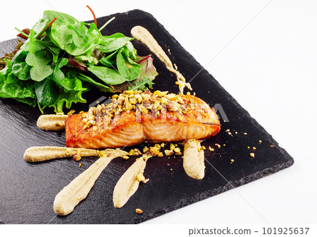Grilled salmon fish fillet with crushed pistachios with green salad Grilled salmon fish fillet with crushed pistachios with green salad 101925637
