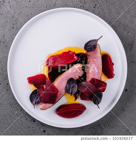 Detail of pork tenderloin prepared on a white plate 101926017