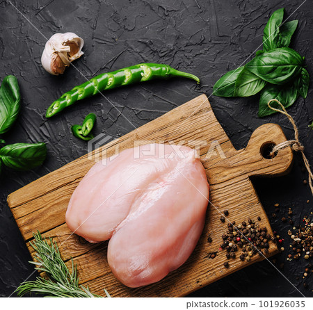 Raw chicken fillets on wooden cutting board, top view 101926035