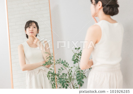 Asian woman looking at the mirror suffering from acne, rough skin and pimples Asian woman looking at the mirror suffering from acne, rough skin and pimples 101926285