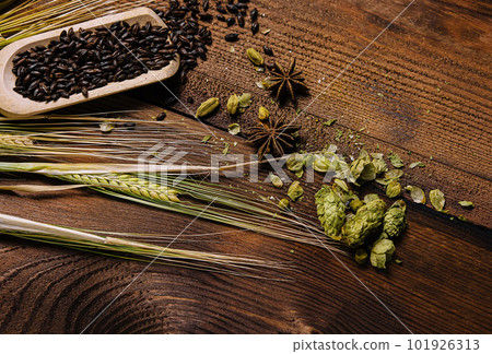 wheat with hops and cinnamon on a wooden background wheat with hops and cinnamon on a wooden background 101926313
