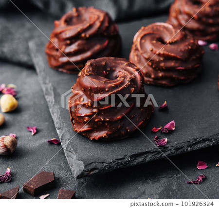 cakes in chocolate glaze on stone board 101926324