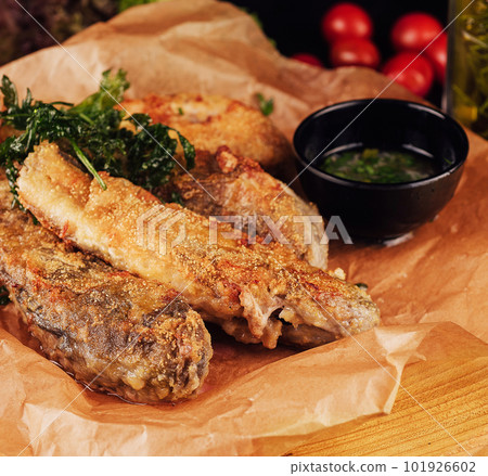 fried fish with garlic sauce on a cutting board fried fish with garlic sauce on a cutting board 101926602