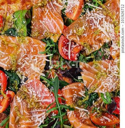 Delicious hot pizza with salmon, cheese, tomatoes and aragula Delicious hot pizza with salmon, cheese, tomatoes and aragula 101926712
