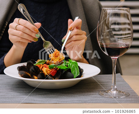 beautiful woman eating pasta with mussels in a restaurant 101926865