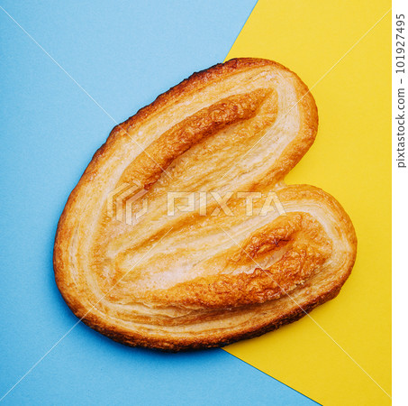 Puff pastry cookies on blue and yellow background 101927495