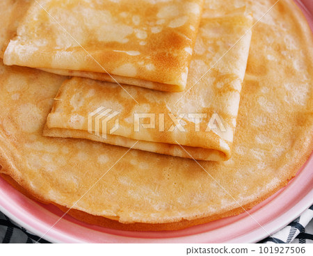Stack of fresh thin pancakes on pink plate 101927506