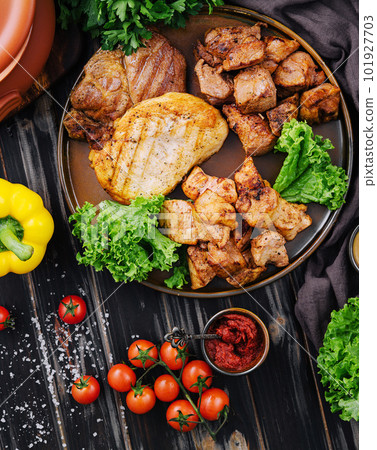 Grilled barbecue meat assortment on dark wood 101927703