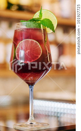 Cold pink cocktail with fresh grapefruit, lime and ice cubes on restaurant table Cold pink cocktail with fresh grapefruit, lime and ice cubes on restaurant table 101927725