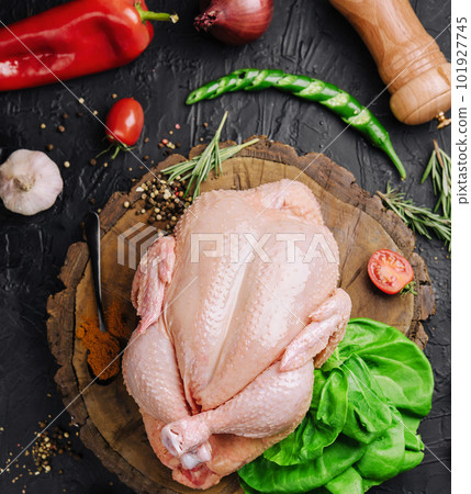 Whole raw chicken on a wooden board with spices for cooking, top view 101927745
