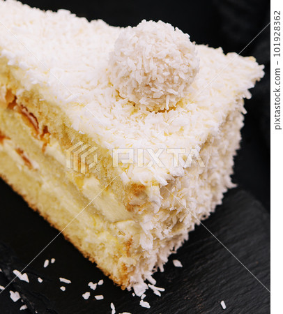 Coconut layered, raffaello cake on black tray 101928362