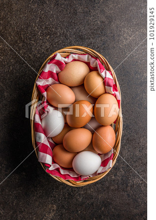 Whole chicken eggs in basket on black table. Top view. Whole chicken eggs in basket on black table. Top view. 101929145