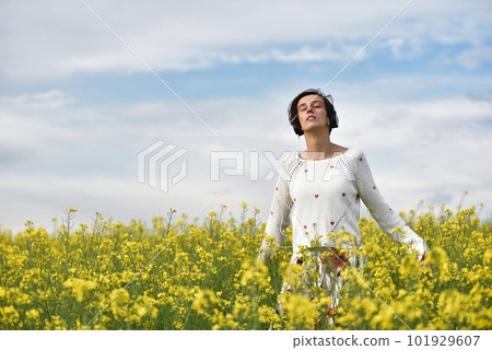 Caucasian girl listening to music with headphone in the outdoors 101929607
