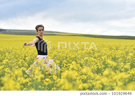 Hipster girl walking through a canola field. Freedom concept Hipster girl walking through a canola field. Freedom concept 101929646