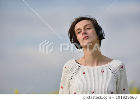 Young beautiful brunette woman girl listening music in headphones in the outdoor 101929660
