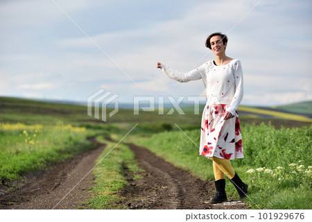 Sexy young woman in skirt hitchhiking near a countryside road Sexy young woman in skirt hitchhiking near a countryside road 101929676