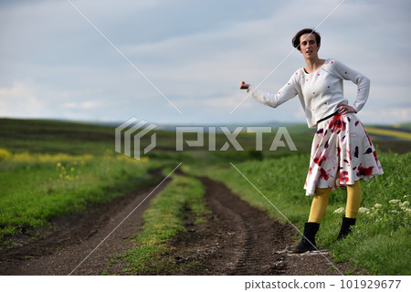 Sexy young woman in dress hitchhiking near a countryside road 101929677