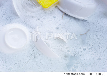 Dishes and bowls with yellow sponge in water and bubbles of dishwashing liquid Dishes and bowls with yellow sponge in water and bubbles of dishwashing liquid 101931033