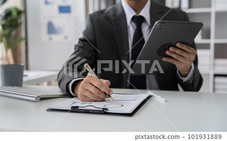 Businessman hand Project manager working and update tasks and Gantt chart scheduling virtual diagram.with tablet and laptop in office. Businessman hand Project manager working and update tasks and Gantt chart scheduling virtual diagram.with tablet and laptop in office. 101931889