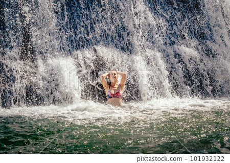 Beautiful lady staying by the waterfall Beautiful lady staying by the waterfall 101932122