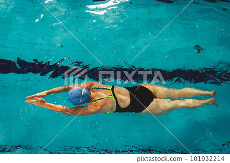 Woman swimming with swimming hat and swimsuit in swimming pool Woman swimming with swimming hat and swimsuit in swimming pool 101932214