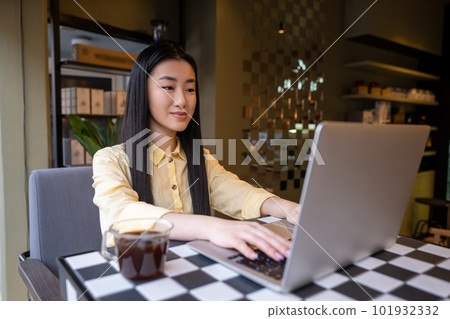 Focused female freelancer working on the computer in a coffeehouse 101932332