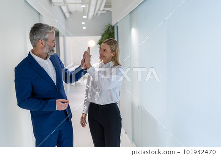 Two joyous businesspeople greeting one another indoors Two joyous businesspeople greeting one another indoors 101932470