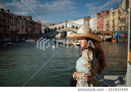 modern solo traveller woman in floral dress with hat 101932489