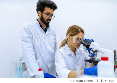 Scientists using microscope, doing sample analysis, talking, team of specialists work in lab. Scientists using microscope, doing sample analysis, talking, team of specialists work in lab. 101932499