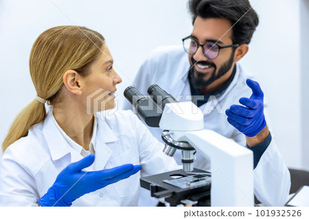 Male scientist working with microscope, doctor's team in laboratory doing research. Male scientist working with microscope, doctor's team in laboratory doing research. 101932526