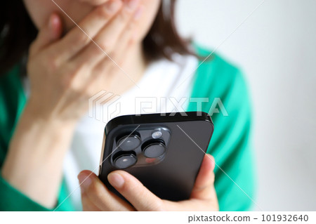 A woman surprised to see a smartphone 101932640