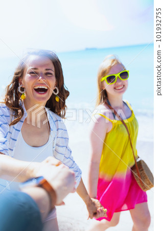 smiling stylish mother and teenage daughter at beach walking 101932755