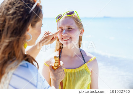 happy modern mother and teenage daughter at beach applying spf happy modern mother and teenage daughter at beach applying spf 101932760