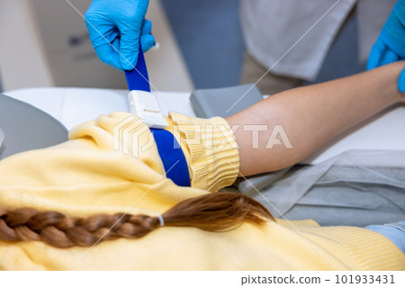 Unrecognizable little patient gave hand to nurse in performs manipulations before mri scan 101933431