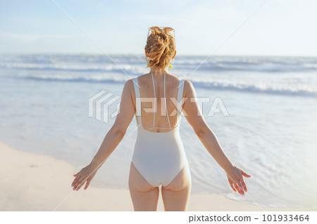 Seen from behind woman in swimsuit at beach relaxing 101933464