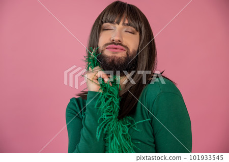 Satisfied enjoyable transgender wearing green feather party dress posing with closed eyes Satisfied enjoyable transgender wearing green feather party dress posing with closed eyes 101933545